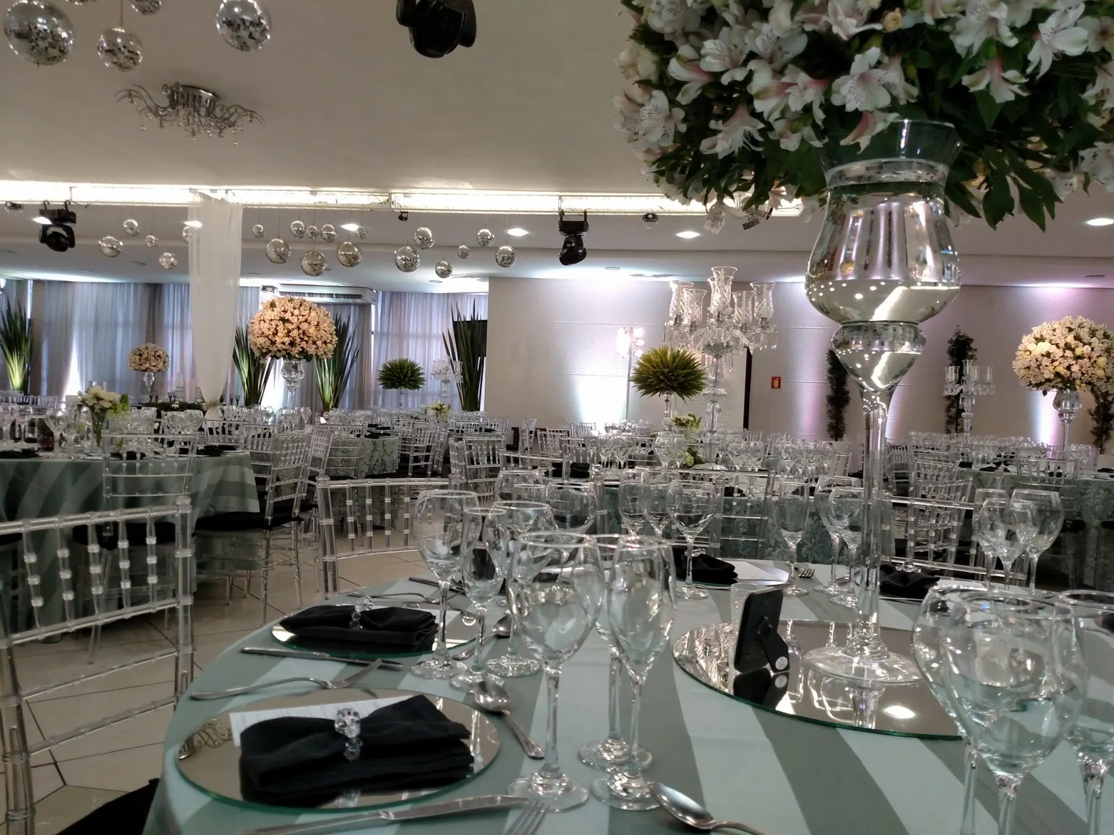 Salão com mesas e arranjos claros para casamento